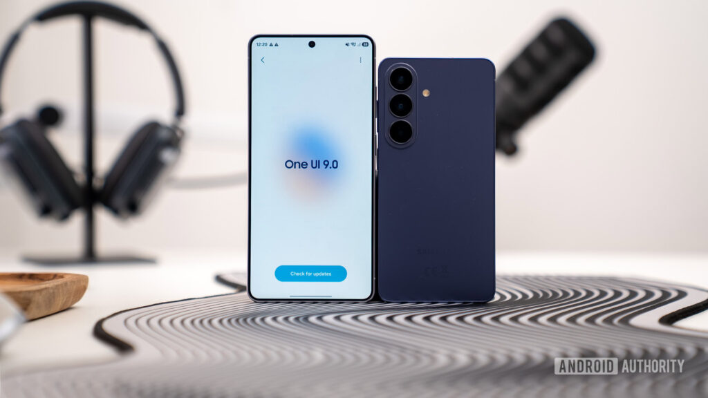 OneUI 9 update screen on S26 Ultra stood next to base S26 straight on